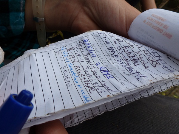 Signing the geocache log book.