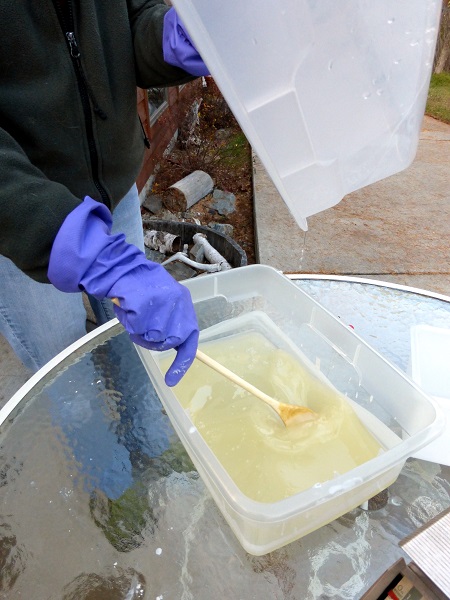 Pouring lye mixture into melted tallow for soap